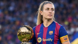 Alexia Putellas in an FC Barcelona women's football jersey beside a golden Ballon d’Or trophy.